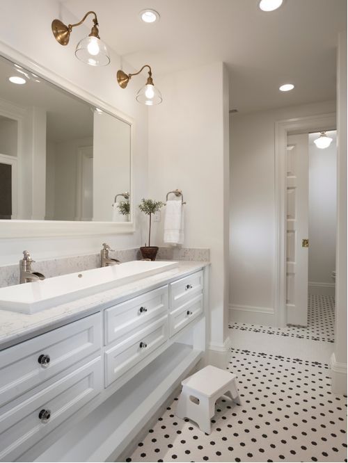 a bathroom with a white sink and black and white floor